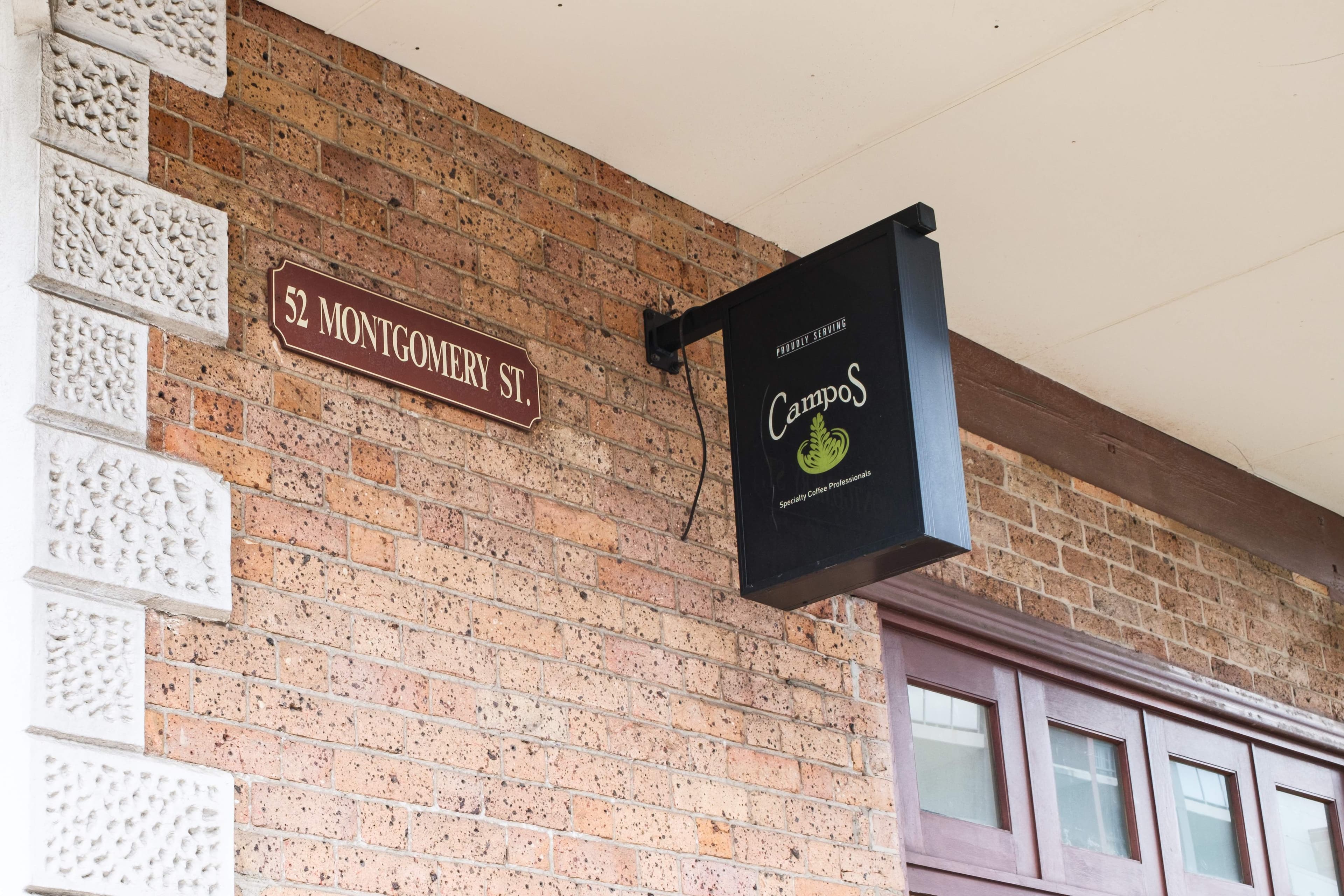 Montgomery Street Cafe's 52 Montgomery St plaque beside the Campos coffee sign.